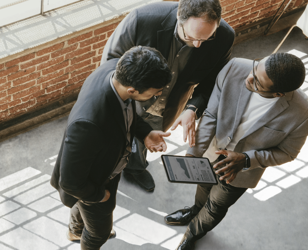 Three business men reviewing data on a tablet