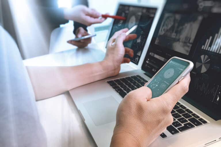 Photo website graphic designer hand working with his team make new project in studio.Modern laptop extend screen digital tablet smart phone on wood table. sun flare effect